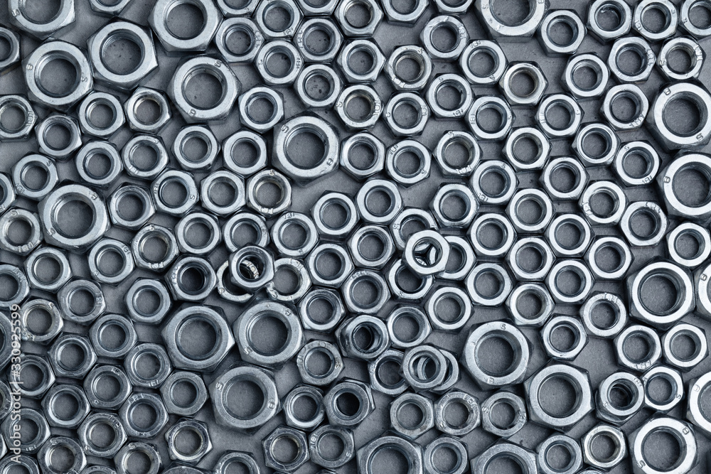 Shiny nuts of various sizes on a granite surface, abstract industrial background Shiny nuts of various sizes on a granite surface, abstract industrial background