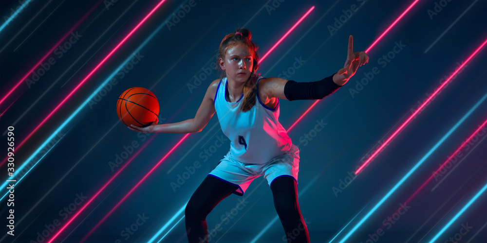 Creative sport and neon lines on dark background, flyer, proposal. Female basketball player training in action and motion. Concept of hobby, healthy lifestyle, youth, action, movement, modern style.
