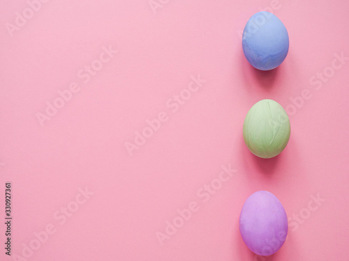 Flat lay composition of Happy Easter holiday concept. Colorful pastel egg on pink background. Copyspace, top view.