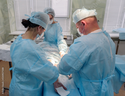 cosmetic liposuction surgery in actual operating room setting showing surgeon hands and cannula