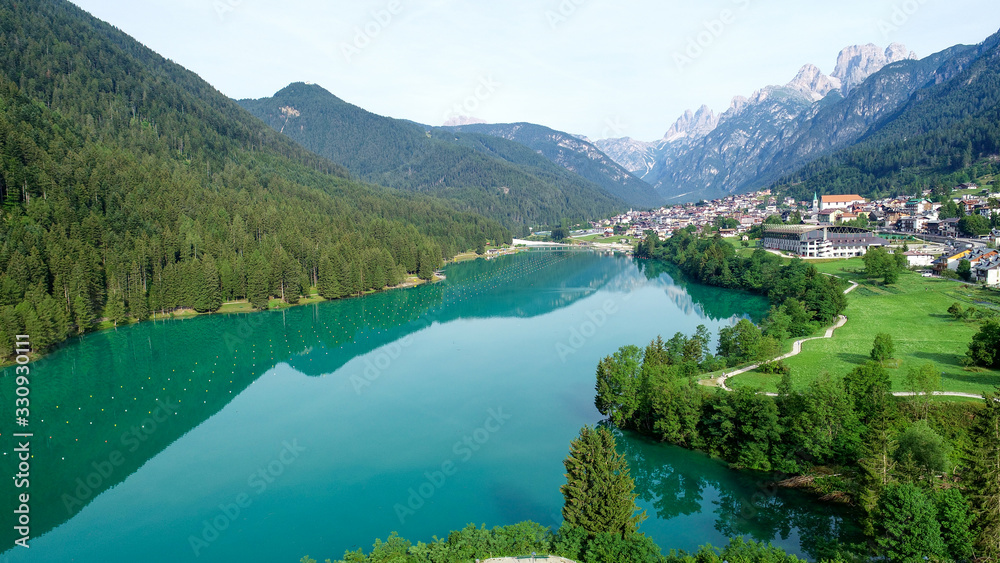 Picturesque alpine lake and village at the foot of snow-capped mountain