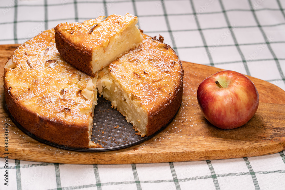 cut off part homemade cake and a red Apple on wooden Board. cut off part homemade cake and a red Apple on wooden Board.