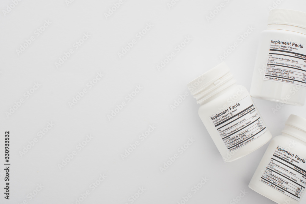Top view of containers with dietary supplements on white Top view of containers with dietary supplements on white