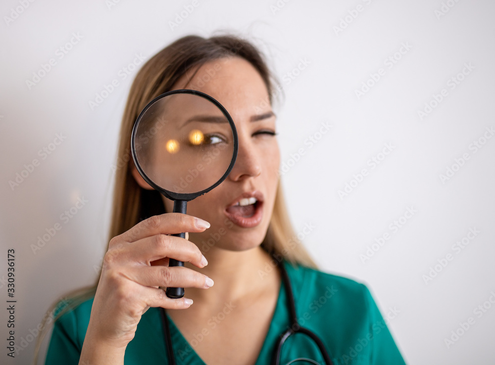 Young attractive woman looking through magnifying glass Young attractive woman looking through magnifying glass