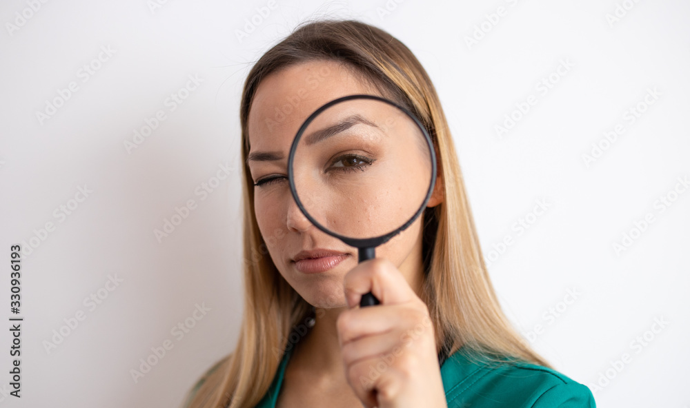 Young attractive woman looking through magnifying glass Young attractive woman looking through magnifying glass