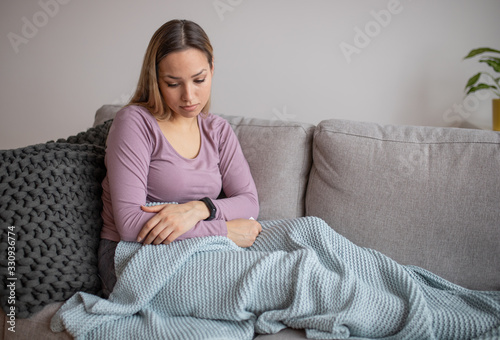 Sad and depressed woman sitting on sofa and looking at distance