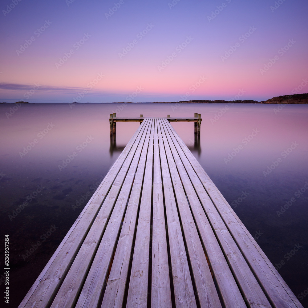 Obraz premium Wooden frosty jetty leading into the sea, Sweden.