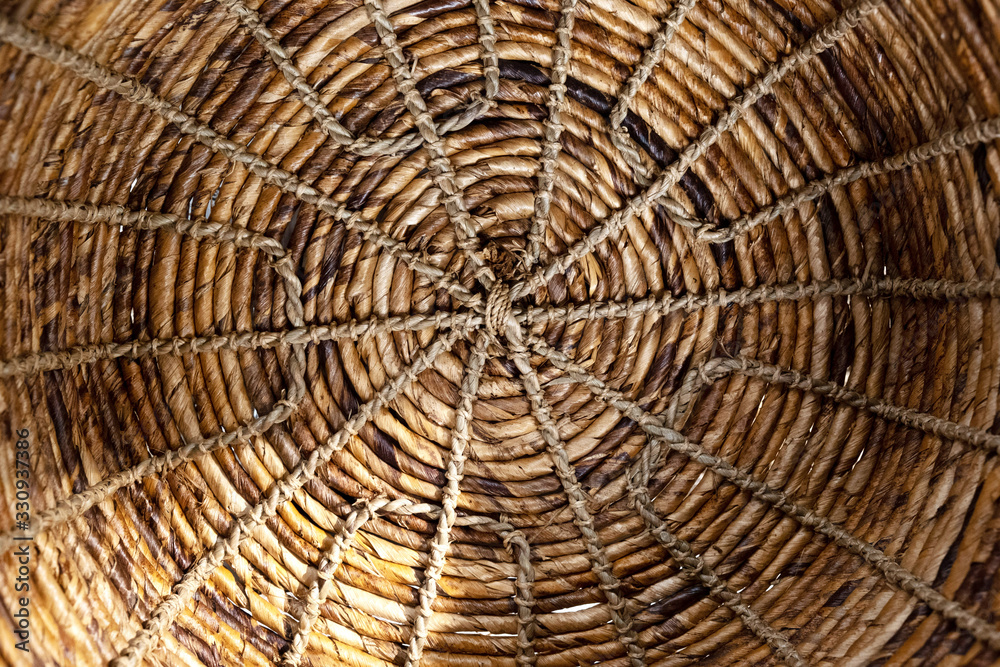 Close-up on a braided round pattern of natural harnesses. Ideal for texture and background. Use of natural materials