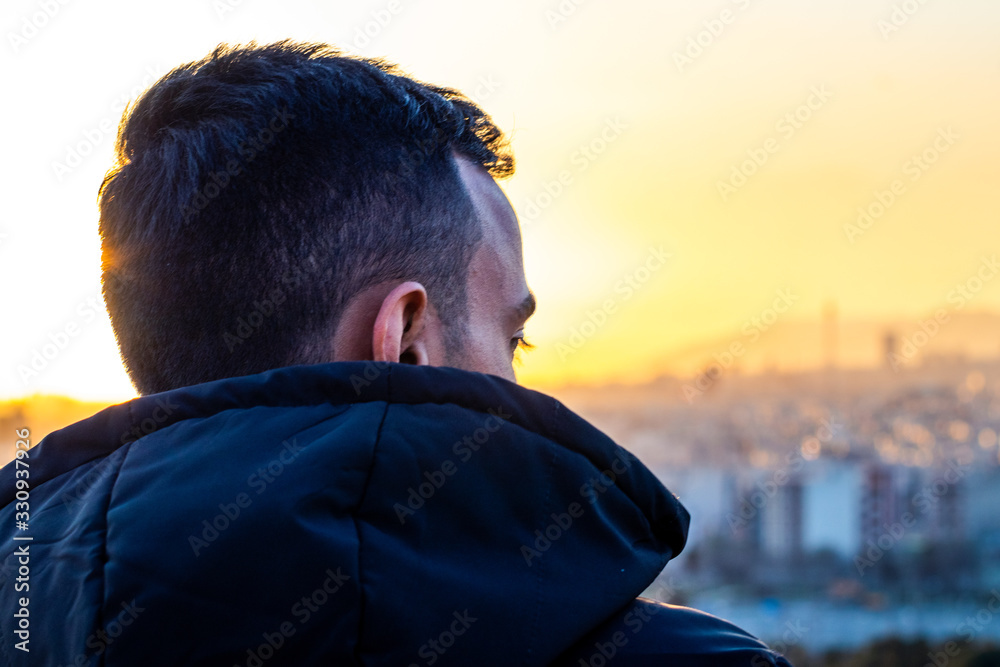 an alone man looking though a city skyline at a beautiful sunset and thinking. an alone man looking though a city skyline at a beautiful sunset and thinking.