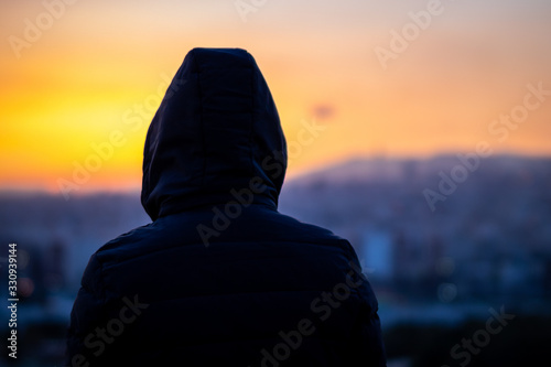 Moody portrait with Tehran skyline at the background. Alone man looking at cityscape of Tehran-Iran at the sunset.
