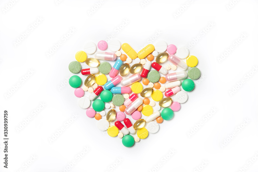 Heart made of multi-colored pills on a white background. Health and medicine concept Heart made of multi-colored pills on a white background. Health and medicine concept