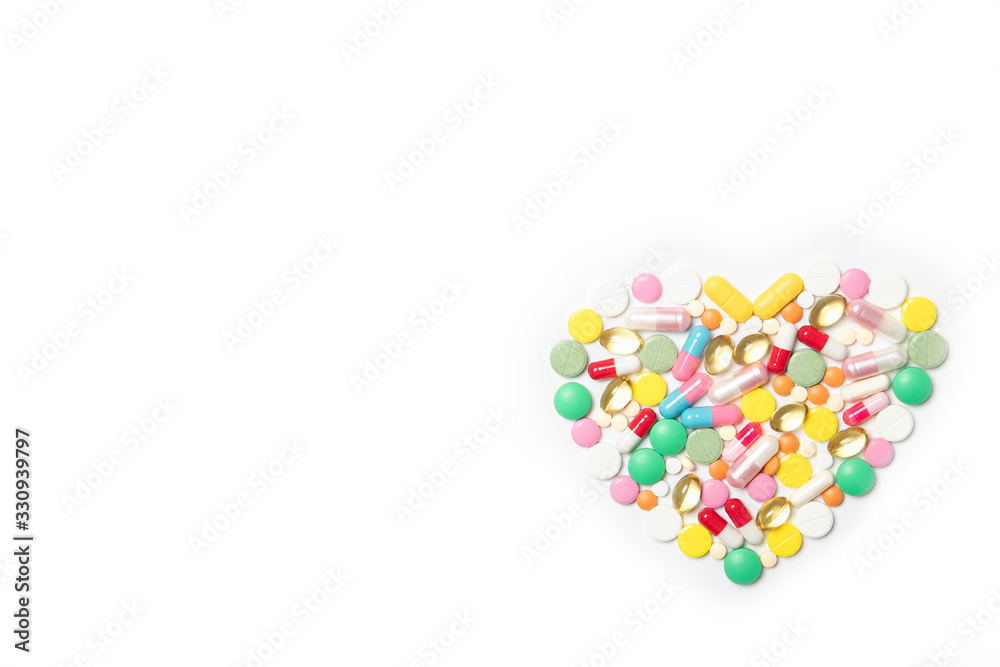 Heart made of multi-colored pills on a white background. Health and medicine concept Heart made of multi-colored pills on a white background. Health and medicine concept