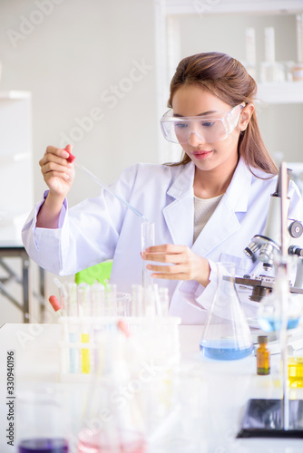 Attractive happiness scientist woman lab technician assistant analyzing sample in test tube at laboratory. Medical, pharmaceutical and scientific research and development concept. © totojang1977