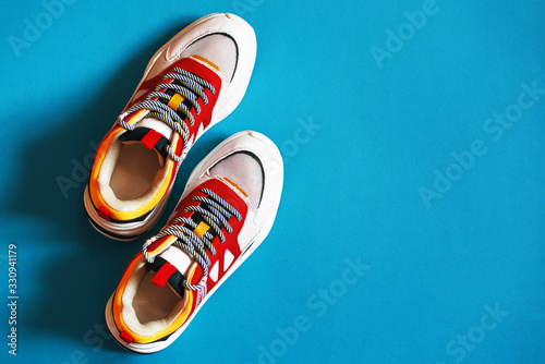 Unisex multi-colored sneakers on a blue background.