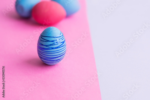 Blue Easter egg on a pink background.