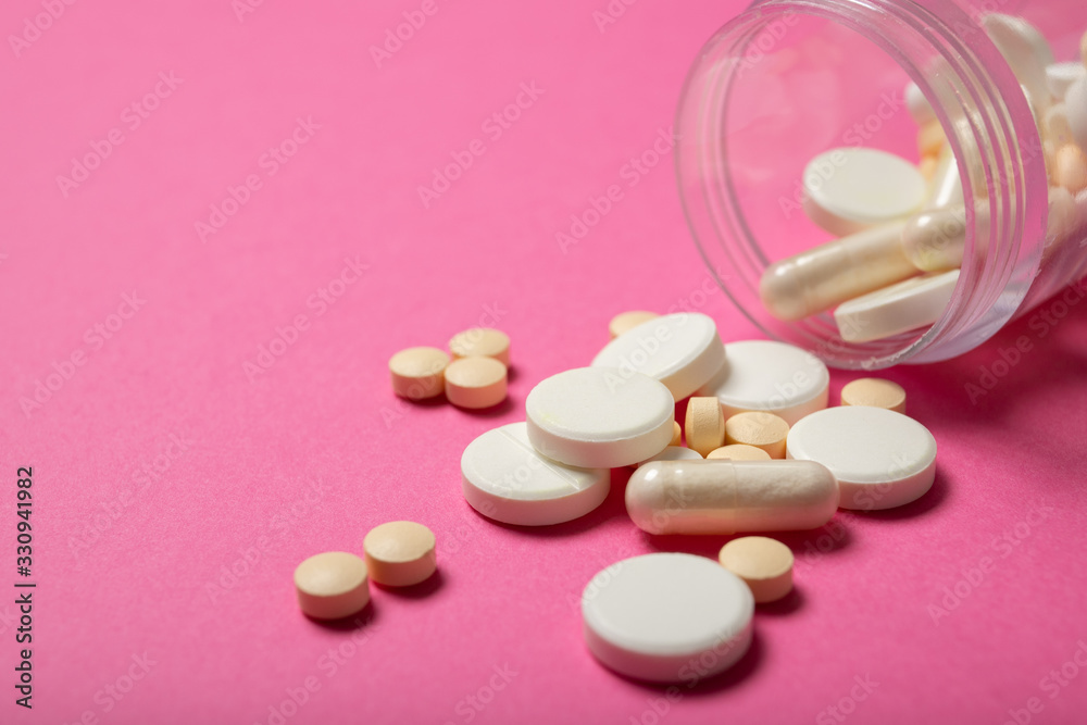 Jar with pills on a pink background. Place for text. Concept of medicine and health Jar with pills on a pink background. Place for text. Concept of medicine and health