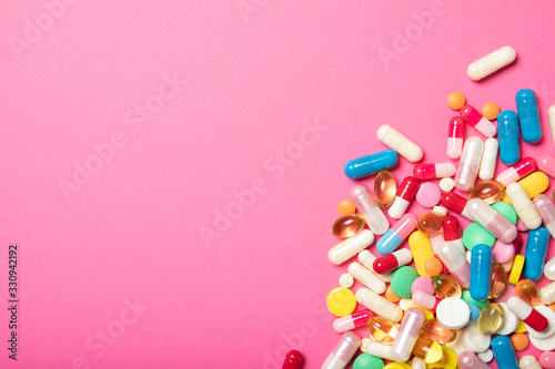 Pills and capsules on a pink background.Concept of medicine and health. Place for text