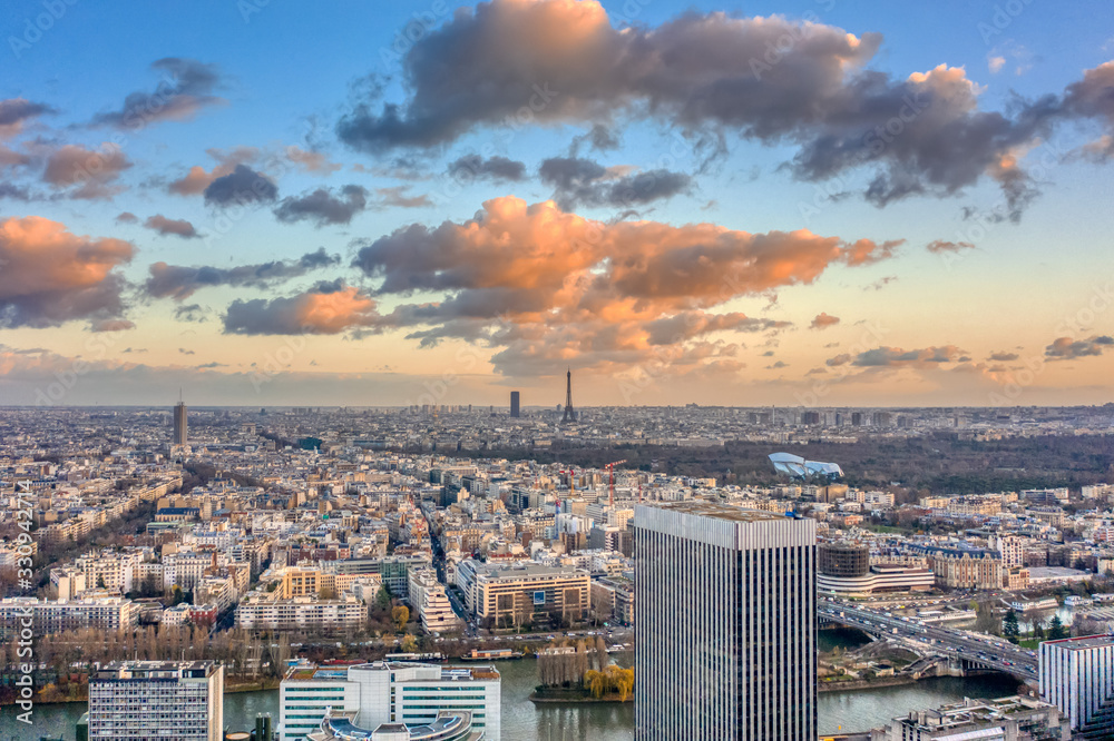 Fototapeta premium Aerial drone shot of Levallois Paris with Eiffel Tower and jardin d'acclimation during sunset time with clouds