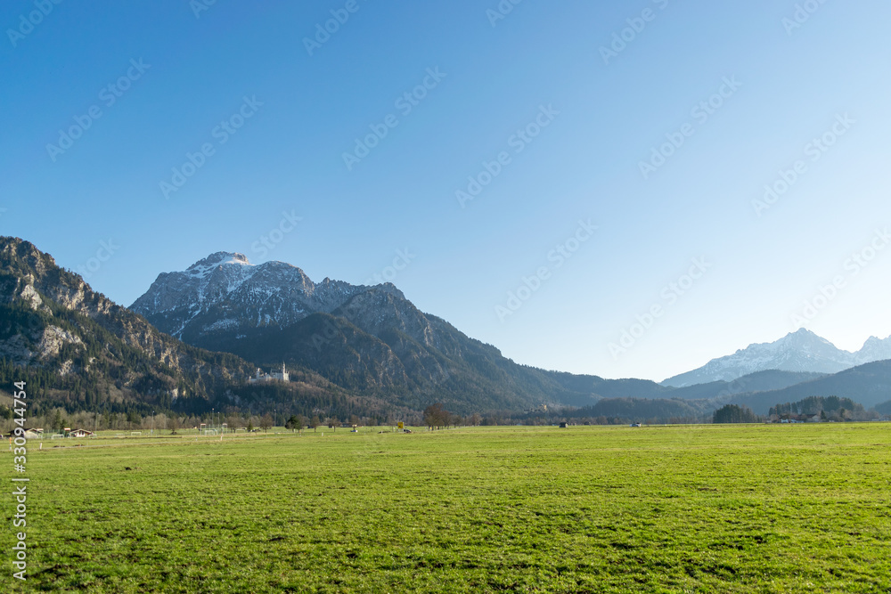 Blick auf das Allgäu-Panorama im Schwangau bei Füssen. Die Landschaft ist geprägt von den Alpen und den weitläufigen Almen. Zahlreiche Touristen besuchen das Ostallgäu wegen Schloss Neuschwanstein.