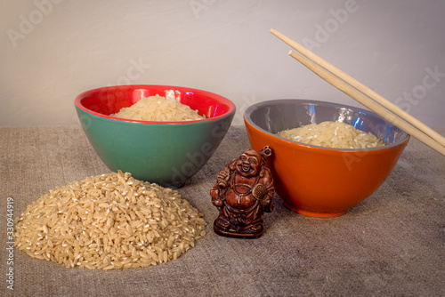 Asian traditional cuisine. The rice in the plates is on the table. Wooden figure of netsuke photo