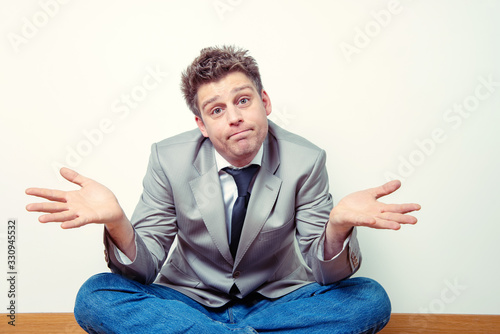 Expressive portrait of a man spreading his arms in a fatalistic way. Business concept. photo
