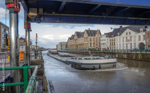 Barge at river Schelde Belgium. Oudenaarde. Freight boat. Inland shipping. Hydraulic bridge. photo