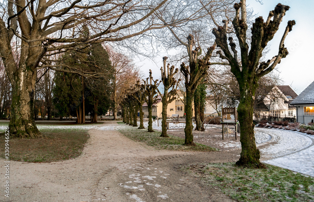 Foot path through Munkehagen park with scenic trees and playground equipment in winter season, Stavanger, Norway, December 2017 Foot path through Munkehagen park with scenic trees and playground equipment in winter season, Stavanger, Norway, December 2017