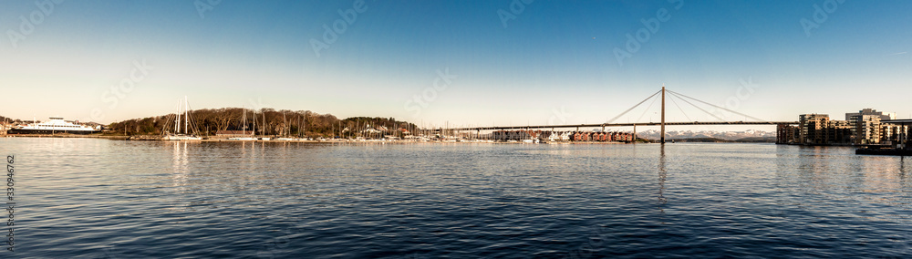 Panoramic view of Stavanger city bridge, marina bay near Grasholmen and Solyst islands and a regular ferry ship, Norway, December 2017