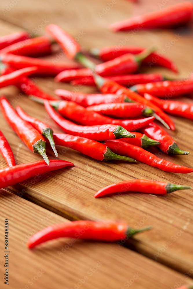 cooking, food and culinary concept - red chili or cayenne pepper on wooden boards cooking, food and culinary concept - red chili or cayenne pepper on wooden boards