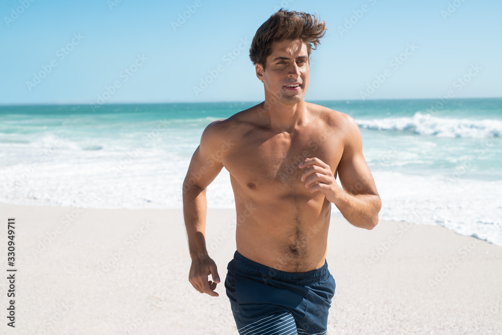 Fit man running on beach