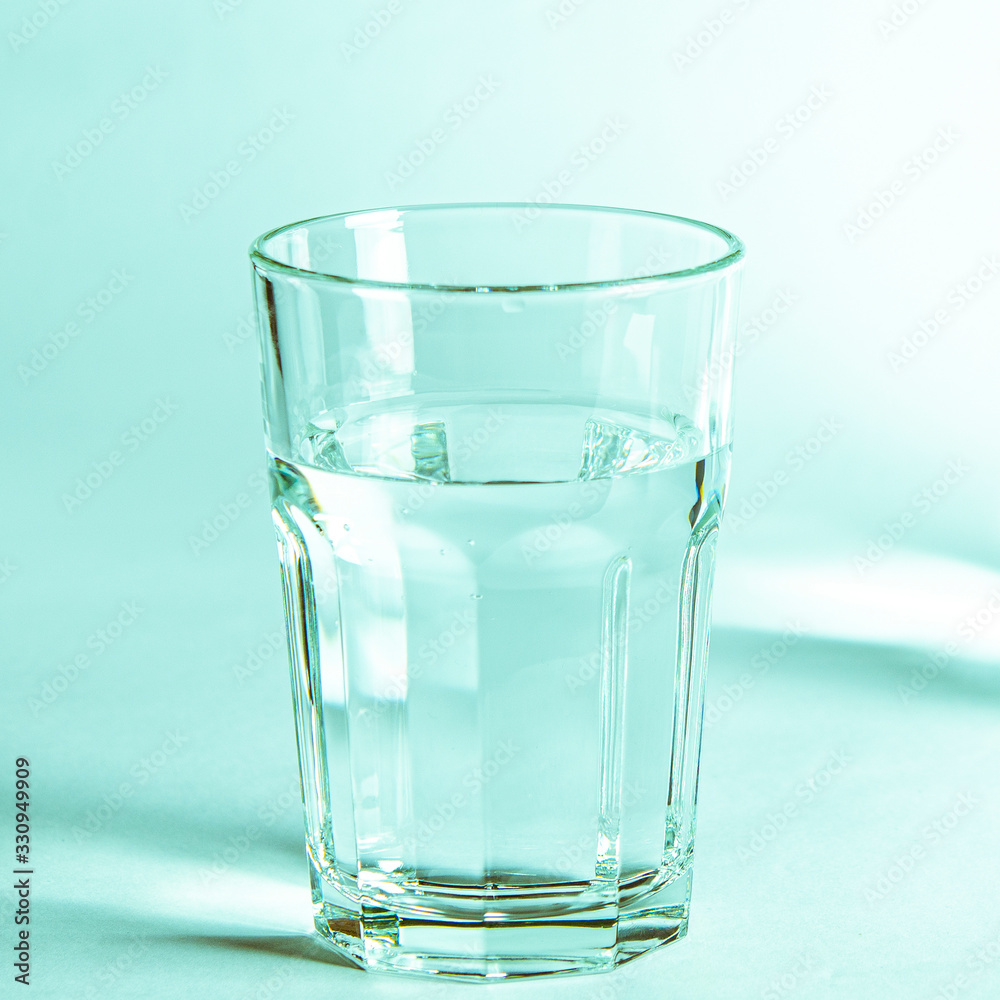 Pure clear water in a glass and jug stands on a white background Pure clear water in a glass and jug stands on a white background