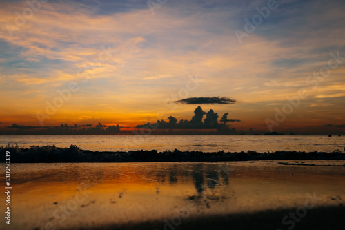 Sunrise, sunset of the sun through the clouds, tropical area near sea.