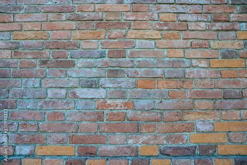 Old brick wall of weathered brick of different colors as a background