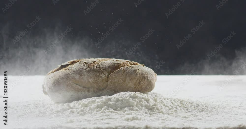 Bakery and cooking concept. Fresh bread with a splash falls into flour