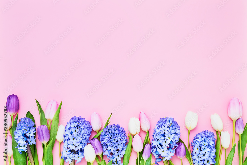 Greeting card. Colorful tulips and hyainths border on pink background. Mothers day, Valentines Day, Birthday celebration concept. Top view, copy space
