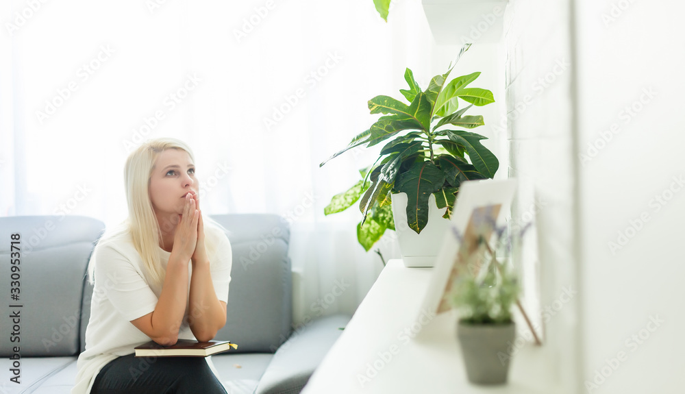 Girl praying. Side view of beautiful young blond hair woman praying at home Girl praying. Side view of beautiful young blond hair woman praying at home