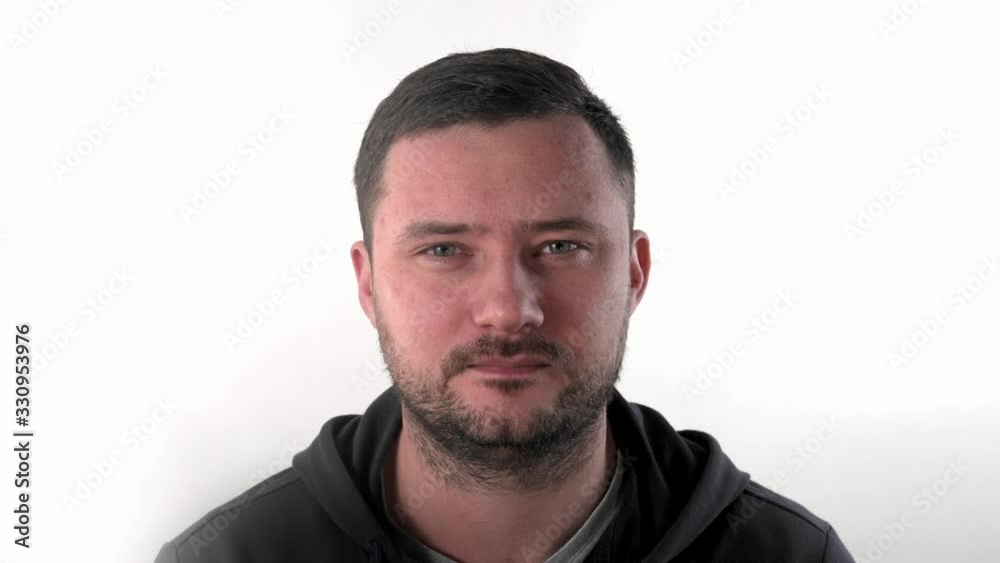 Portrait of caucasian man with short dark hair and mustaches posing, looking strait on camera and down, being calm and peaceful over white background in studio closeup. Portrait of caucasian man with short dark hair and mustaches posing, looking strait on camera and down, being calm and peaceful over white background in studio closeup.