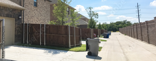 Panoramic concrete back alley with trash containers of new residential housing in Allen, Texas, USA photo