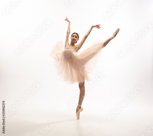 Graceful classic ballerina dancing, posing isolated on white studio background. Tender peach tutu. The grace, artist, movement, action and motion concept. Looks weightless, flexible. Fashion, style.