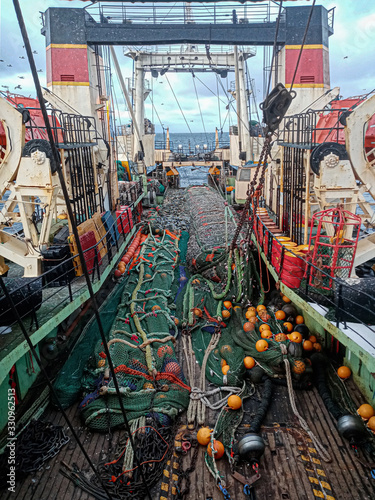 Fishing with a trawl. A large trawl with fish was dragged onto the deck of the ship