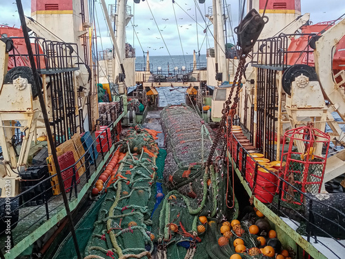 Fishing with a trawl. A large trawl with fish was dragged onto the deck of the ship