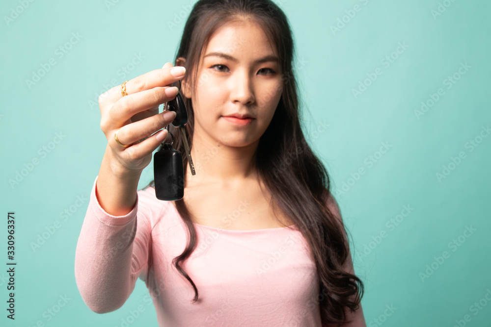 Cute asian girl showing home residence keys. Cute asian girl showing home residence keys.