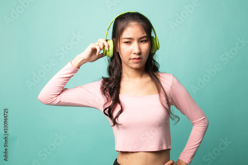 Too loud. portrait of young asian woman holding headphones and making unhappy face.