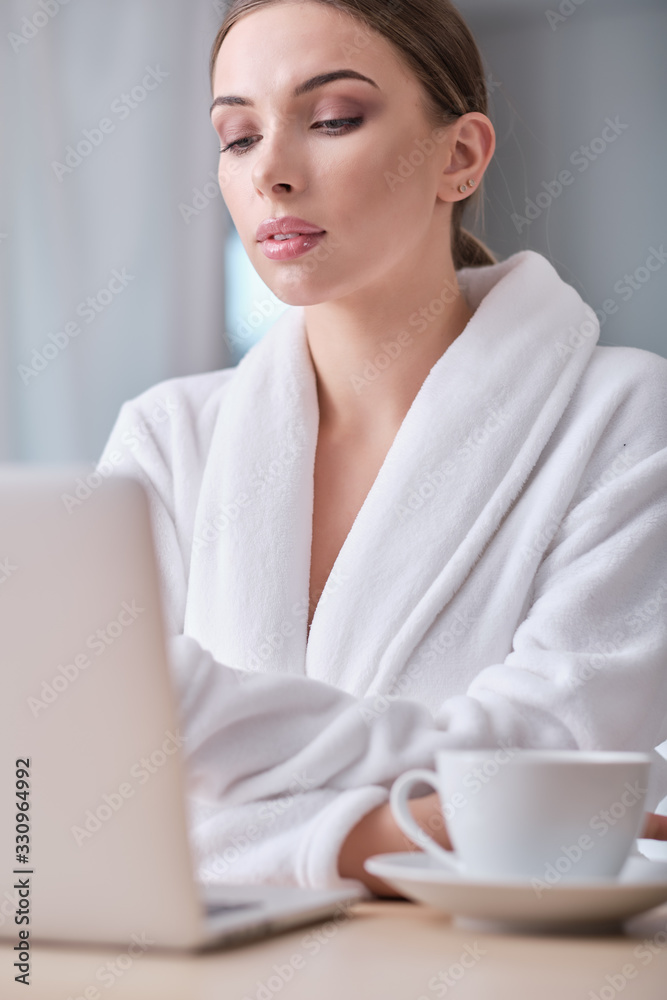 coronavirus epdemic. , woman looking at laptop while at home in office work space .
