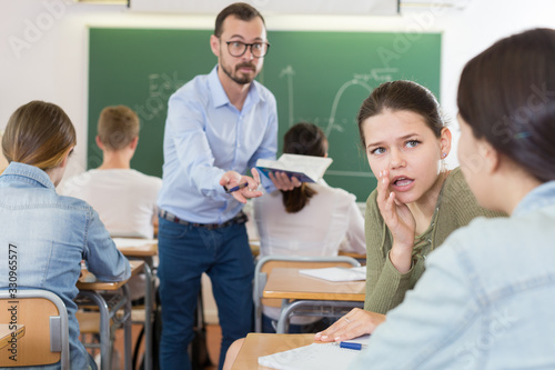 Two girl are talking in time lecture and teacher is disturbance it