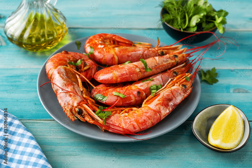 Close up of huge argentinian red prawns on aqua menthe background Close up of huge argentinian red prawns on aqua menthe background