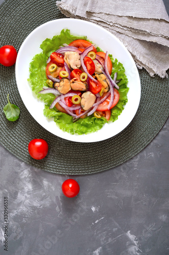 Salad of marinated mussels, fresh tomatoes, red onions, olives in a white bowl. The top view