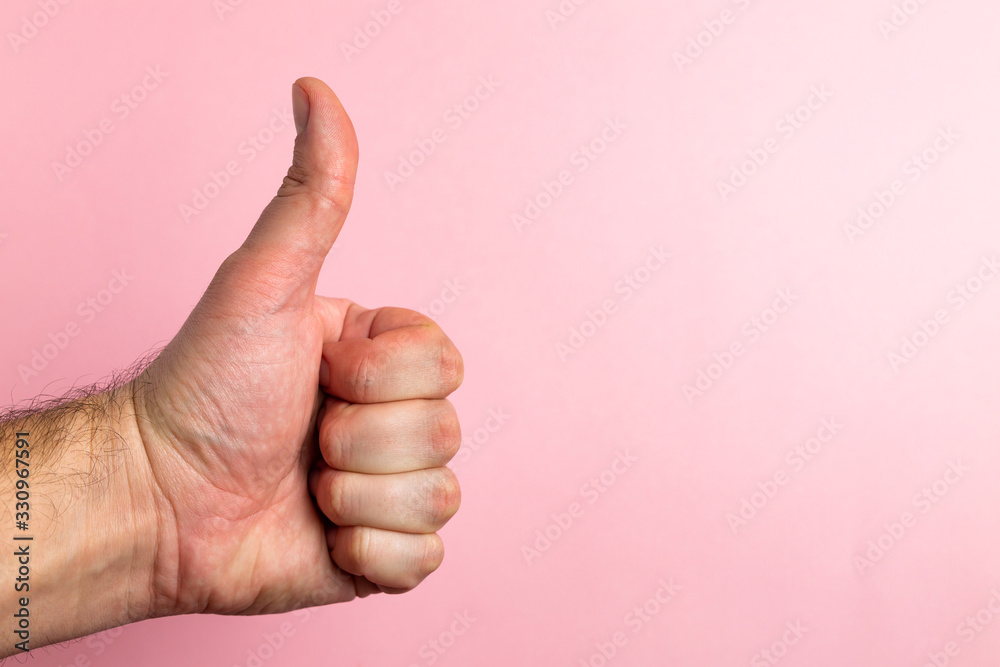 hand with thumb upwards on a pink background