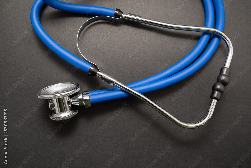 Stethoscope on black background, top view. Medical instrument