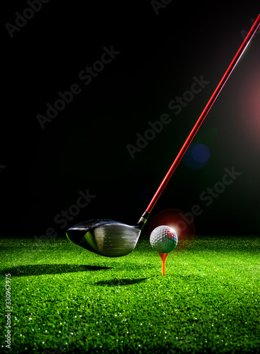 Vertical close up shot of a golf ball and golf driver on the turf